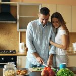Happy young couple in the kitchen. Handsome man meet his girlfriend early morning at home